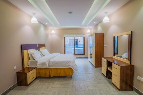 a bedroom with a large bed and a large mirror at La Famille Guest House-Families Onlyللعوائل فقط in Durat Alarous
