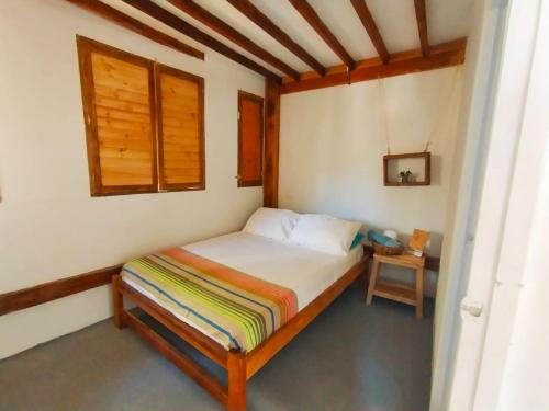 a small bedroom with a bed in a room at Quatro palos in Rincón