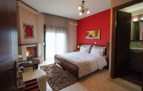 ein rotes Schlafzimmer mit einem Bett und einem Kamin in der Unterkunft Guesthouse Liogerma in Kato Loutraki