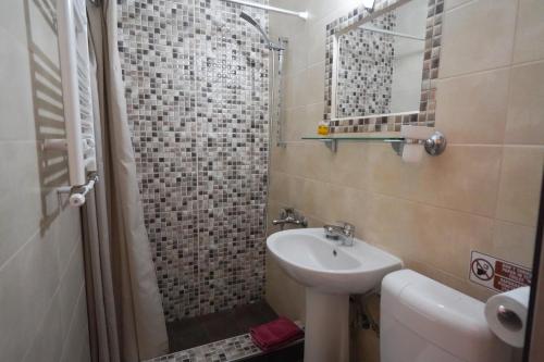 ein kleines Bad mit einem Waschbecken und einer Dusche in der Unterkunft Guesthouse Liogerma in Kato Loutraki