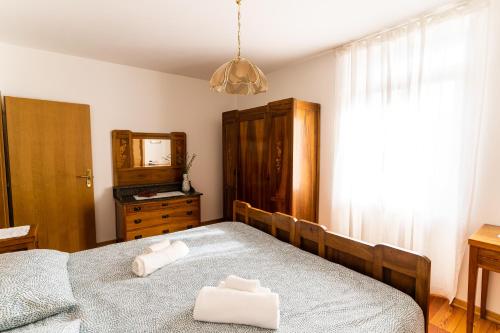 a bedroom with two beds and a dresser and a mirror at Casa Lena in Ledro