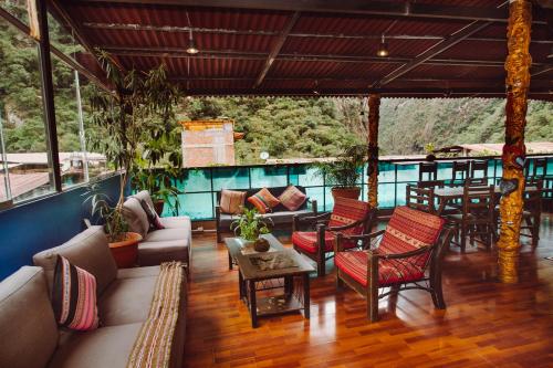 uma sala de estar com mobiliário e uma mesa em Nativus Hostel Machu Picchu em Machu Picchu