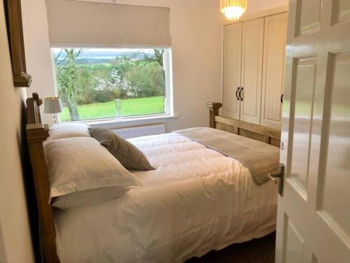 um quarto com uma cama grande e uma janela em ValleyView Cottage-Cosy, Rustic Home - Log Burner em Ushaw Moor