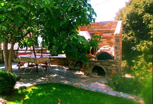 a brick oven in a yard with a table and chairs at Archontiko Elena in Volos