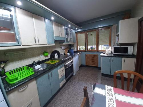 a kitchen with blue cabinets and a green basket on the counter at Villa en la Reserva de la Biosfera de Gordón in Huergas y El Millar