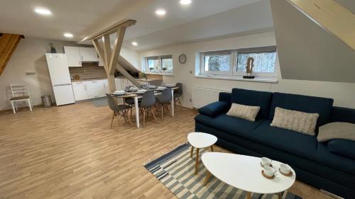 a living room with a blue couch and a table at Apartmány Herc in Jáchymov