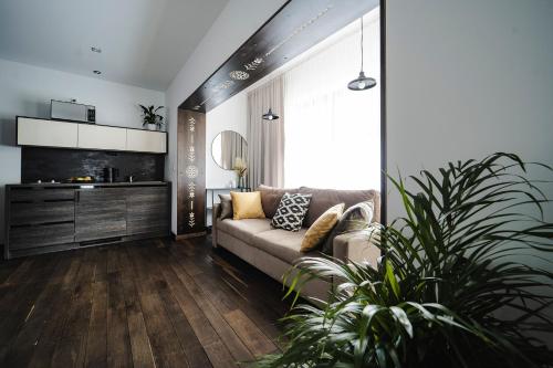 a living room with a couch and a plant at IJG Imperial Apartamenty Krupówki in Zakopane