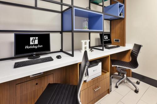 an office with a desk with two monitors and a chair at Holiday Inn St Johns by IHG in St. John's
