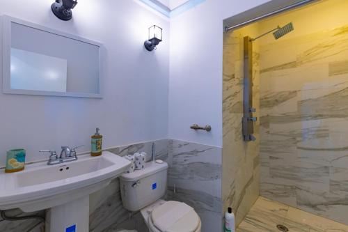 een badkamer met een wastafel, een toilet en een douche bij Sunshine Studio at Viking Hill - Love Beach in Nassau