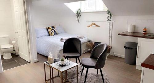 a bedroom with a bed and two chairs and a table at CityNights Studios with Free Parking in Liverpool