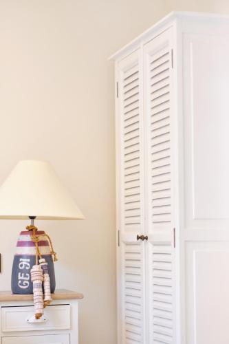 a white closet door with a lamp on a table at Au Petit Manoir in Socx