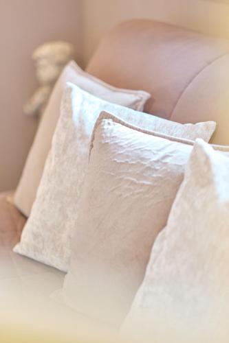 a pile of white pillows on a bed at Au Petit Manoir in Socx
