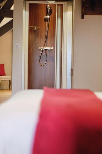 a bedroom with a red pillow in front of a door at Au Petit Manoir in Socx