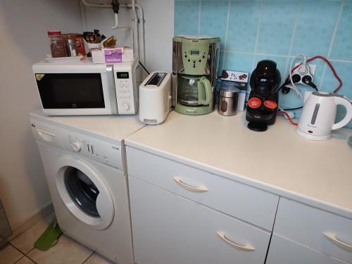 a kitchen counter with a washing machine and a microwave at Studio centre ville tout confort in Nevers