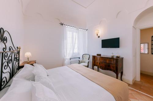 a bedroom with a bed and a desk and a television at L'Olearia Luxury Country Villa in Amalfi Coast in Maiori