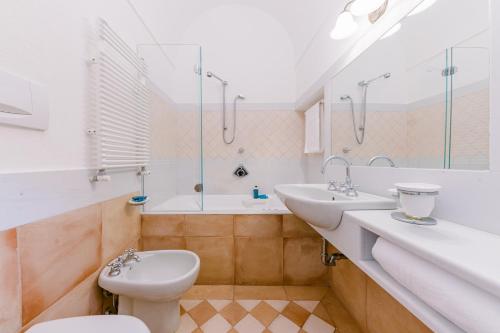 a bathroom with two sinks and a toilet and a tub at L'Olearia Luxury Country Villa in Amalfi Coast in Maiori