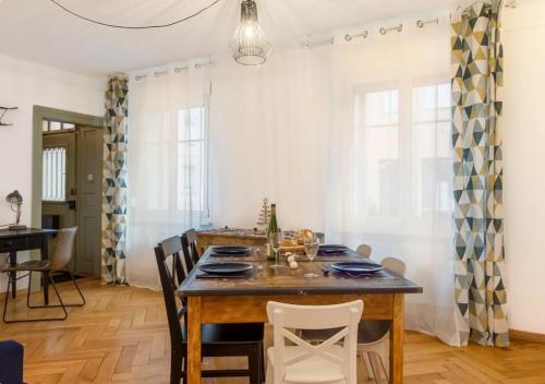 une salle à manger avec une table et des chaises en bois dans l'établissement Thann Colmar - 1 chambre - 5 pers - Parking, à Colmar