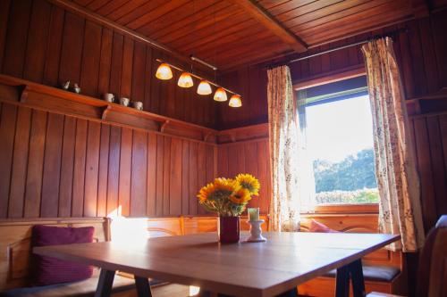 una habitación con una mesa de madera con un jarrón de flores. en Gitstapper Hof natuurhuis, en Wassenberg