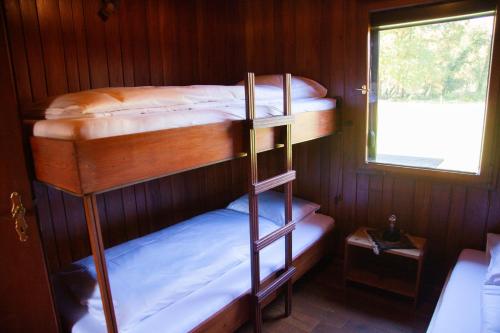 two bunk beds in a room with a window at Gitstapper Hof natuurhuis in Wassenberg