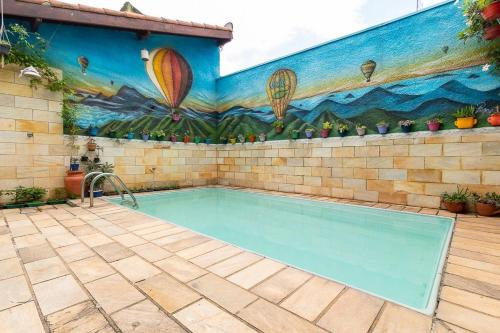 una piscina con un mural de globos de aire caliente en Vale Hostel, en Pindamonhangaba