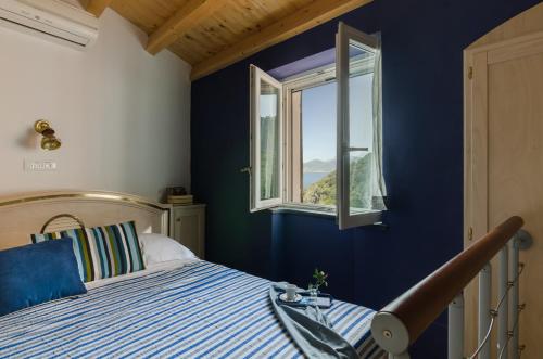 a blue bedroom with a bed and a window at La Casetta Rossa in Corniglia
