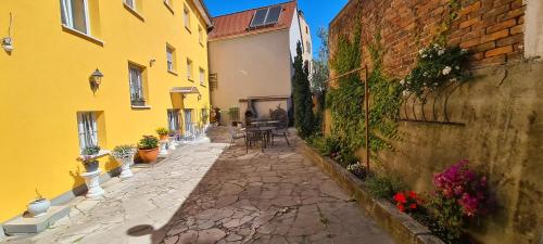 an alley between two buildings with chairs and flowers at Hotel Lamm in Stuttgart