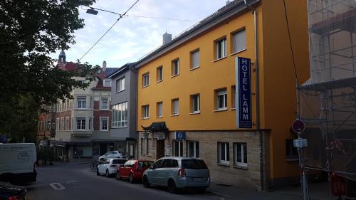 un edificio amarillo al lado de una calle en Hotel Lamm en Stuttgart