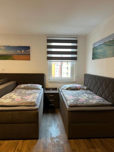 a bedroom with two beds and a window at Apartman Centrum 403 in Ústí nad Labem