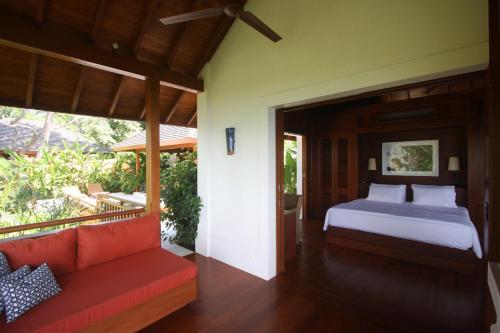 Bejuco的住宿－Canta La Rana，一间卧室配有一张床和一张沙发