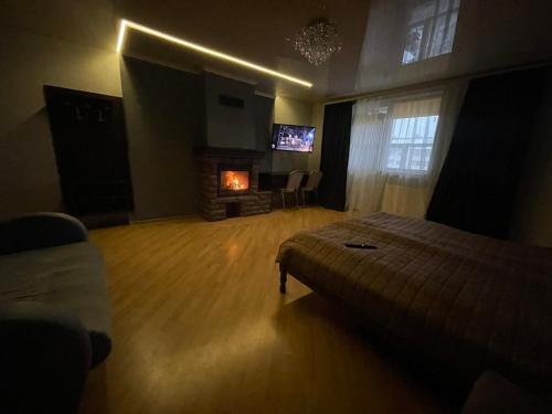 1 dormitorio con 1 cama, chimenea y TV en LIKE HOTEL en Kolomiya