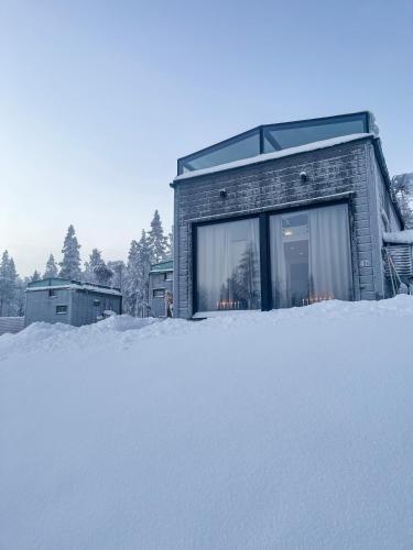 a house in the snow with a pile of snow at Levi Sensu - Levi Sky Igloos in Levi