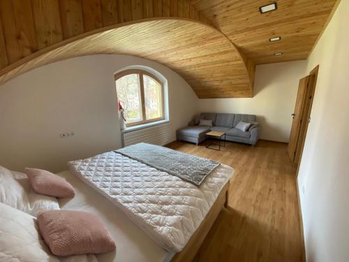 een slaapkamer met een groot bed en een bank bij Yes Dream apartment in Jeseník