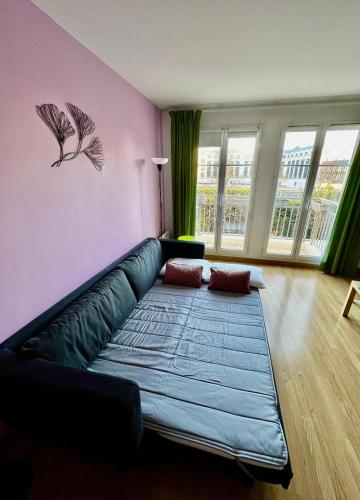 un salon avec un canapé bleu dans un mur rose dans l'établissement La suite des fleurs Disneyland Paris, à Chessy