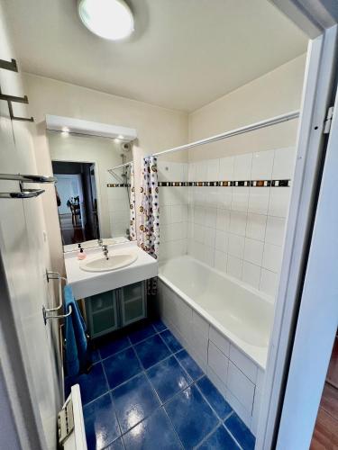 une salle de bain avec une baignoire et un lavabo dans l'établissement La suite des fleurs Disneyland Paris, à Chessy