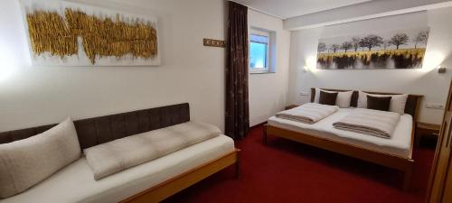 um quarto de hotel com duas camas e um sofá em Apart Holiday em Kappl