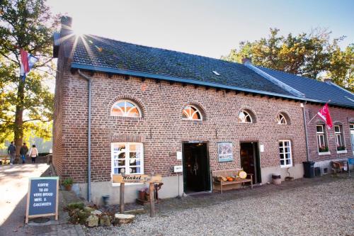 a brick building with a sign in front of it at Gitstapper Hof natuurhuis in Wassenberg