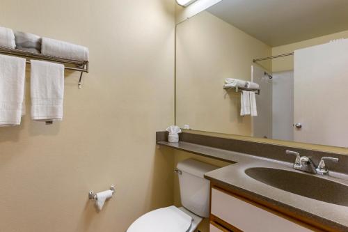 a bathroom with a sink and a toilet and a mirror at Suburban Studios Albuquerque Uptown in Albuquerque