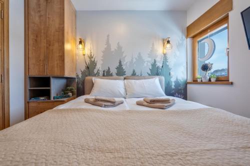 a bedroom with a bed with two towels on it at Apartman Prima Plus in Zlatibor