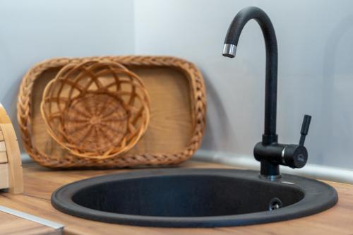 a kitchen sink with a faucet and a basket at V&Dj in Zlatibor