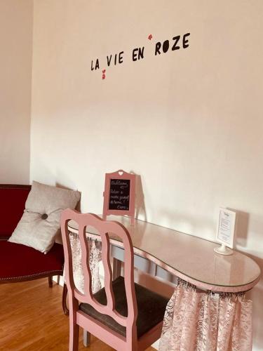 a table with two chairs and a sign on a wall at B&B Villa Belle Epoque in Durbuy