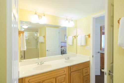 a bathroom with two sinks and a large mirror at Soundside Holiday Beach Resort in Pensacola Beach