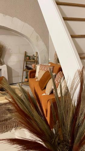 uma sala de estar com um sofá com almofadas em Le Gîte des Rochettes, 600m à pied du Zoo de Beauval em Saint-Aignan