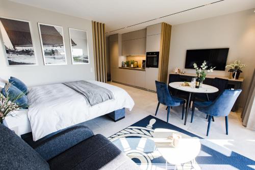 a bedroom with a bed and a table and a kitchen at BALTIC VIEW Supreme Apartment GARDENIA in Dziwnów