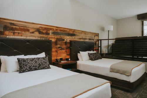 a bedroom with two beds and a brick wall at Huntley Lodge at Big Sky Resort in Big Sky