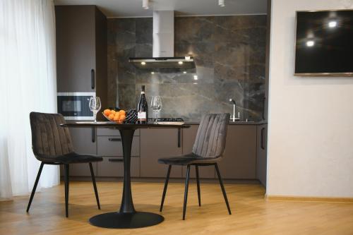 a kitchen with a table with two chairs and a sink at Люкс-студія проспект Миру Netflix in Khmelʼnytsʼkyy