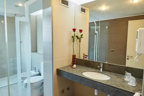 y baño con lavabo, aseo y espejo. en Hotel Torremayor Lyon, en Santiago