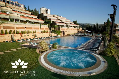 a large swimming pool in front of a building at Monteverde Hotel in Beit Meri