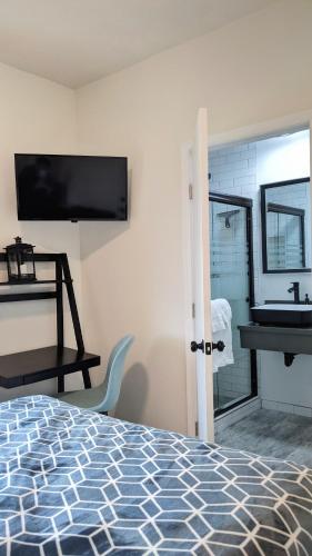 a bedroom with a bed and a bathroom with a sink at Anchor Pointe Inn in Wilmington