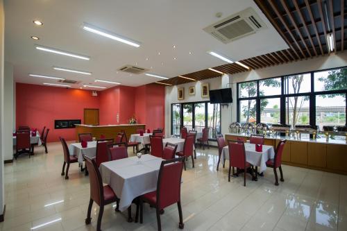 a restaurant with tables and chairs and a bar at Mamaison Hotel in Buriram
