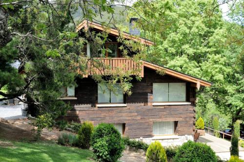 a wooden house with a balcony on top of it at Hotel Rural Las Rozuelas in Cercedilla